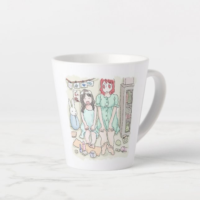 Two women's illustrations sit leaning against the  latte mug (Right Angle)