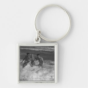 Two young men and woman playing in wave B&W Key Ring