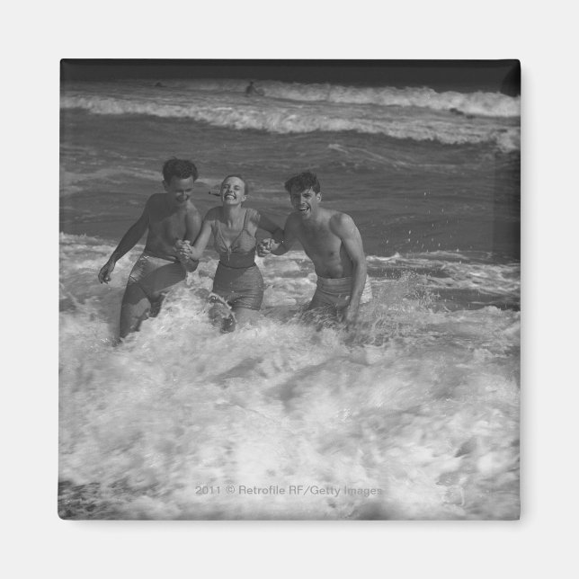 Two young men and woman playing in wave B&W Magnet (Front)