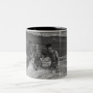 Two young men and woman playing in wave B&W Two-Tone Coffee Mug