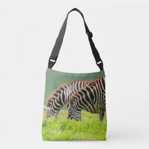 Two zebras eating grass, Serengeti national park. Crossbody Bag