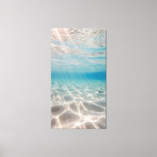 Underwater sunlight shimmers on the sandy seabed canvas print