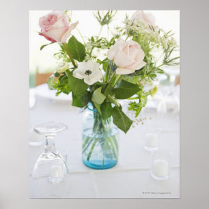 Vase of roses on set dinner table with glasses poster