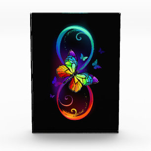 Vibrant infinity with rainbow butterfly on black photo block
