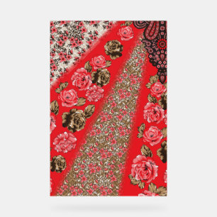 Vibrant red fabric featuring intricate floral and  acrylic sign
