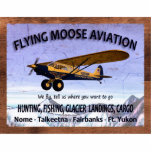 Vintage Flying Moose Aviation Sign Standing Photo Sculpture<br><div class="desc">A weathered sign advertising the services of mythical Flying Moose Aviation of Talkeetna, Alaska. It features one of the company's blue-and-Yellow aircraft equipped with extra-large "tundra tires" for landing on rough terrain . Text reading, "FLYING MOOSE AVIATION", "We fly, tell us where you want to go", "HUNTING, FISHING, GLACIER LANDINGS,...</div>