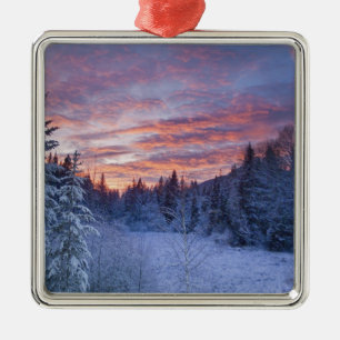 Vivid sunset paints the sky above wintery metal tree decoration