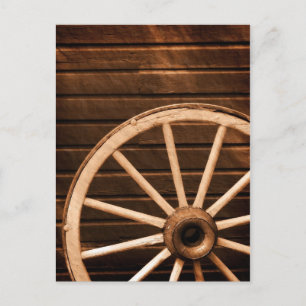 Wagon wheel leaning against old wooden wall postcard