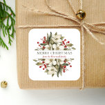 Watercolor Merry Christmas Floral Magnolia Berries Square Sticker<br><div class="desc">This personalised holiday sticker features a watercolor bouquet of white magnolia blossoms,  greenery and red berries. In the middle,  the words "Merry Christmas" appear in olive green serif font on a white background. Personalise the design with your family name below in dark red italics.</div>