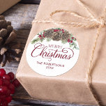 Watercolor Pine Cone Script Merry Christmas  Classic Round Sticker<br><div class="desc">This beautiful Christmas sticker features elegant script calligraphy,  family name and year,  and is decorated with watercolor pine cones,  greenery sprigs,  and burgundy red holly berries. Check out the collection for many matching products,  or contact me through Zazzle Chat if you would like additional matching products or other colorways.</div>