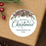 Watercolor Pine Cone Script Merry Christmas Green Classic Round Sticker<br><div class="desc">These personalised Christmas stickers are great for envelope seals on your holiday mail, gifts and favours, and more. They feature elegant script calligraphy, family name and year, and is decorated with watercolor pine cones, greenery sprigs, and burgundy red holly berries. Check out the collection for matching products, or contact me...</div>