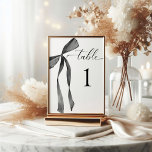 Watercolor Ribbon Bow Black and White Wedding Table Number<br><div class="desc">Introducing our stunning Watercolor Ribbon Bow Black and White Wedding Collection. This exquisite collection is a true work of art, radiating elegance and sophistication. Adorned with a delicate black ribbon bow, it is the ideal choice for couples who desire a classic and refined aesthetic for their special day. The collection...</div>