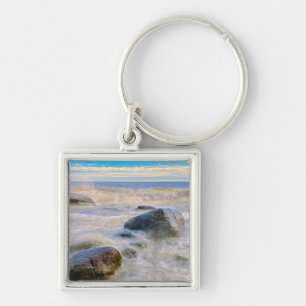 Waves crashing on shoreline rocks key ring