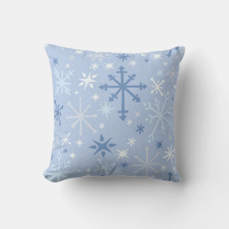 Whimsical snowflake flurry in blues on icy blue cushion