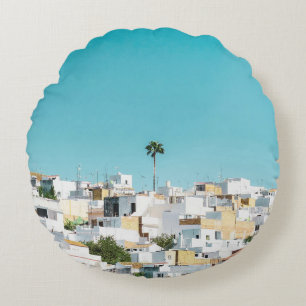 White and brown concrete houses under blue sky in round cushion
