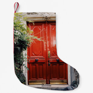 WHITE BUILDING SHOWING CLOSED RED WOODEN DOOR SMALL CHRISTMAS STOCKING