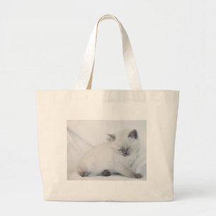 White cat grooming itself large tote bag