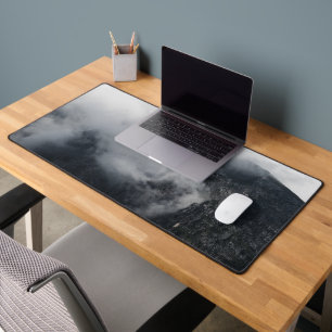 White clouds over the dark rocky mountains desk mat