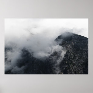 White clouds over the dark rocky mountains poster