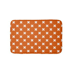 White cross stitches on burnt orange bath mat