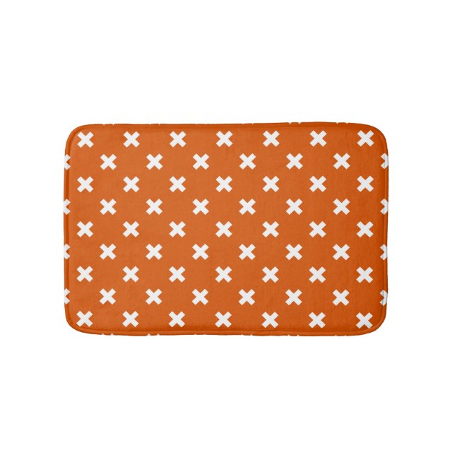 White cross stitches on burnt orange bath mat (Front)