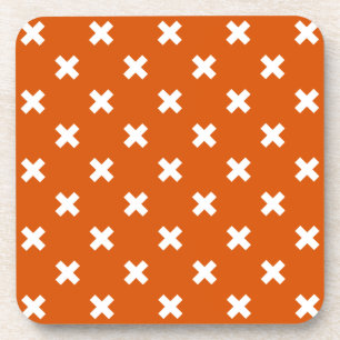 White cross stitches on burnt orange coaster