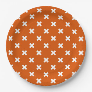 White cross stitches on burnt orange paper plate