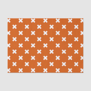 White cross stitches on burnt orange tissue paper