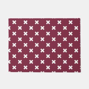 White cross stitches on mulberry doormat
