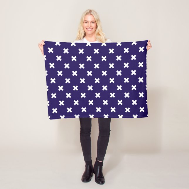 White cross stitches on navy blue fleece blanket (In Situ)