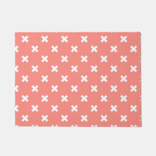 White cross stitches on peach doormat