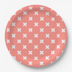 White cross stitches on peach paper plate