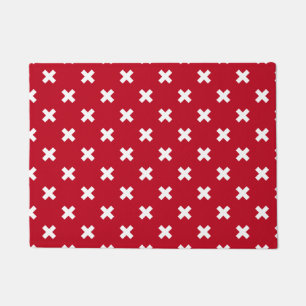 White cross stitches on red doormat