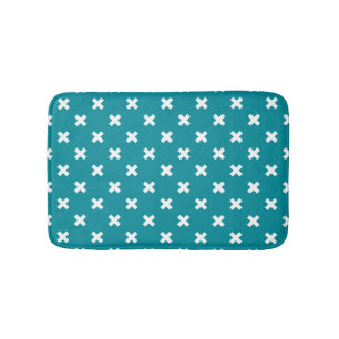 White cross stitches on teal bath mat
