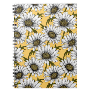 White daisies, wild flowers on yellow notebook