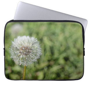 White dandelion flower on green grass laptop sleeve