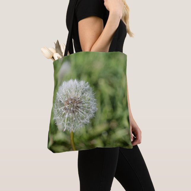 White dandelion flower on green grass tote bag (Close Up)