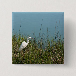 White egret standing in grass w water 15 cm square badge