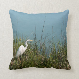 White egret standing in grass w water cushion