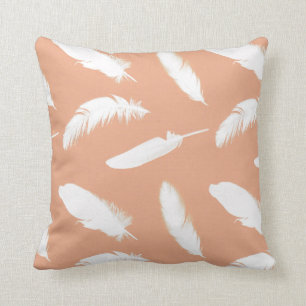 White feather print on soft peach cushion