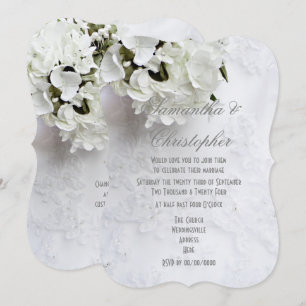 White flowers on brides dress wedding invitation
