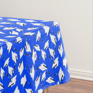 White Graduation Caps on Bright Blue Tablecloth