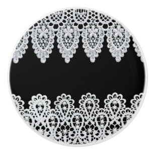 White lace forms a delicate border against black ceramic knob