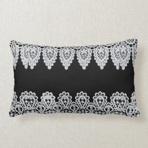 White lace forms a delicate border against black lumbar cushion