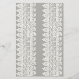 White lace forms a delicate border against black stationery