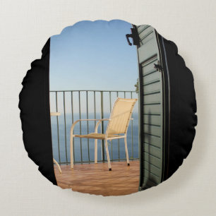 White metal armchair beside fence in the morning round cushion