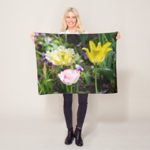 White, pink and yellow tulips in the garden fleece blanket