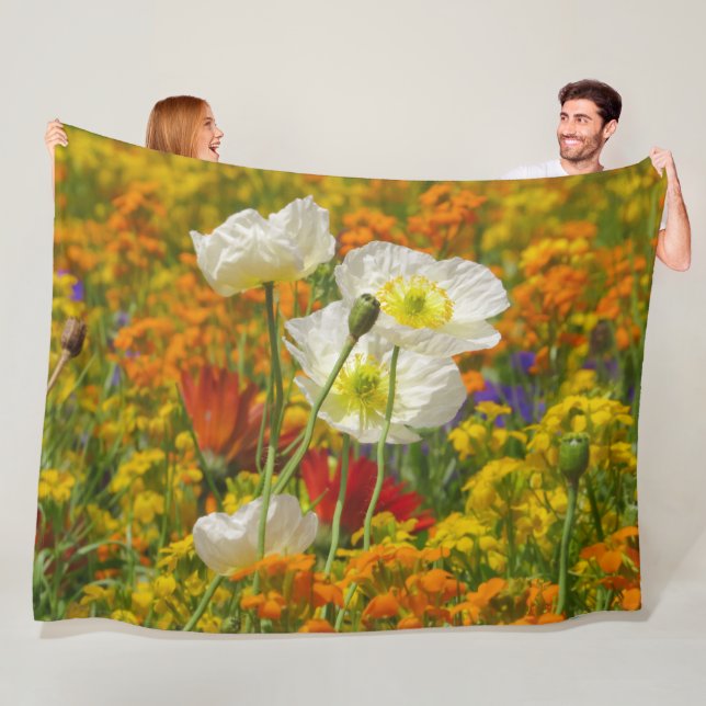 White poppies growing around the colourful flowers fleece blanket (In Situ)