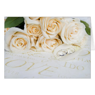 white roses and wedding rings