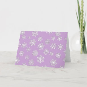 White snowflakes against soft lavender holiday card